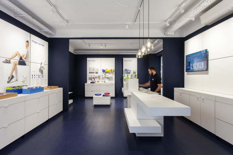 SEEGER医疗用品商店空间设计，地板墙壁的深蓝色与纯白色家具形成鲜明对比